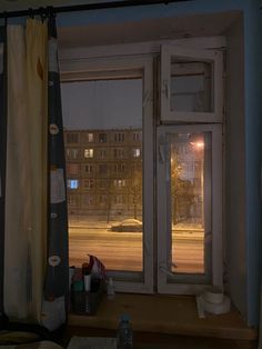 an open window with the view of a street at night