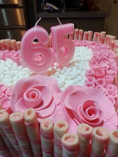 a birthday cake decorated with pink icing and flowers