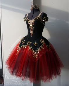 a black and red dress with gold accents