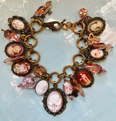 "Hand crafted Cameo charm bracelet all done in Ivory, cream, Ivory with gold, Vintage Cameos in IVORY color and Ivory with Carnelian Victorian lady.   Vintage resin cameo ladies. Vintage cameos with flowers.  The glass is all Vintage Czech pale pink glass. Vintage Venetian Lampwork beads.  Vintage Hong Kong Cream colored resin flowered and a figurine cabochons from the 1960s and the 1980s. Also smaller resin vintage flowered cabochons. All in vintage style settings. Vintage charms in copper and Vintage Hong Kong, Key Heart, Vintage Jewelry Repurposed, Victorian Hand, Feminine Necklace, Junk Jewelry, Repurposed Jewelry, Victorian Lady, Vintage Cameo