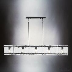 a rectangular chandelier with five lights hanging from it