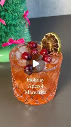 a holiday aperoli margarita with cranberries and orange slices