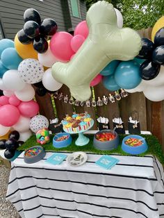 a table topped with lots of balloons and desserts