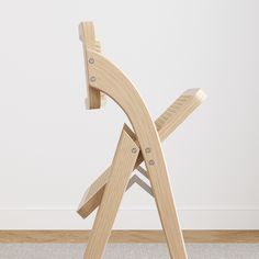 a wooden chair sitting on top of a carpeted floor next to a white wall