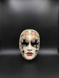 "Size: one size Traditional and original papier-mache Venetian mask, handmade and decorated with trimmings, stucco and acrylics. This traditional Venetian mask shape is called \"Volto mask\" and is a full face mask. This mask remembers Harlequin for the style of the decoration and its coloros. All our masks are handmade papier-machè masks, made in Venice. Our decorators use techniques typical of the Venetian tradition such as stucco, acrylics, gold and silver-leaf, macramè, passementerie, pearls Volto Mask, Venice Mask, Mask Shapes, Costume Masks, Venetian Mask, Full Face Mask, Costume Mask, Full Face, Silver Leaf