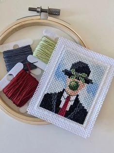 a close up of a cross stitch pattern on a hoop with some scissors and thread