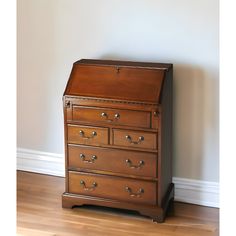 an old wooden chest of drawers against a wall