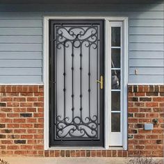 a black iron door on the side of a brick house