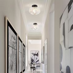 the hallway is decorated in white and black with art on the walls, along with paintings