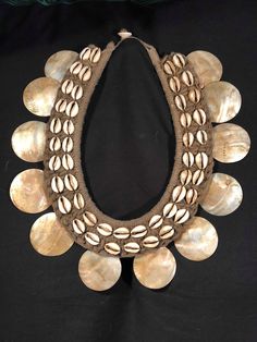 a necklace made out of shells on a black background