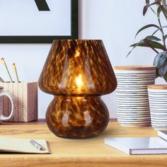 a brown vase sitting on top of a wooden table