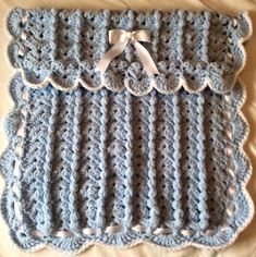 a crocheted blanket with a bow on it