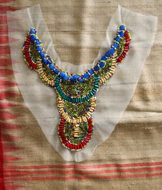 a colorful beaded necklace is displayed on a piece of cloth