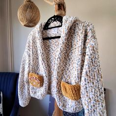 a sweater hanging on a clothes rack next to a blue chair