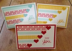 three cards with hearts on them sitting on top of a wooden table next to each other