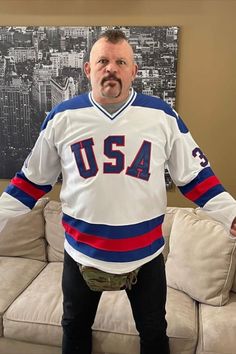 a man standing in front of a couch with his hands on his hips wearing a jersey that says usa