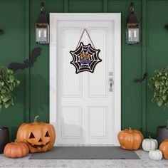 a front door decorated for halloween with pumpkins and spider web