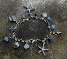 Handmade by me silver plated charm bracket with various sea themed charmed and semi precious stones including turquoise, aquamarine, flourite. Length of bracelet 20cm.  All items come wrapped in tissue and in small gift bag. Please check out my other themed charm bracelets and necklaces. Thank you Ocean-inspired Charm Bracelet As A Gift, Ocean-inspired Blue Charm Bracelet For Gifts, Ocean-inspired Charm Bracelet Gift, Handmade Silver Ocean-inspired Bracelets, Handmade Ocean-inspired Charm Bracelet As A Gift, Handmade Ocean-inspired Charm Bracelet For Gift, Handmade Ocean-inspired Charm Bracelet For Gifts, Handmade Silver Charm Bracelet For Beach, Silver Charm Bracelet With Natural Stones For Gift