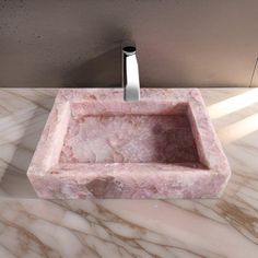 a pink marble sink sitting on top of a counter