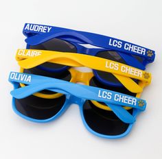 three pairs of blue and yellow sunglasses with los cheer on them