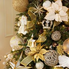 a christmas tree decorated with gold and silver ornaments, including poinsettia ornament