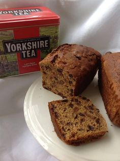 three pieces of bread on a plate next to a box of yorkshire tea and a can of tea