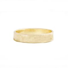 a yellow gold wedding ring on a white background