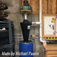 the inside of a garage with tools and equipment on it, including a blue barrel