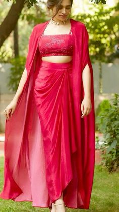 This stunning red draped saree is perfect for any festive occasion. The ensemble features a beautifully pleated skirt that adds movement and grace. The matching blouse, adorned with intricate embroidery, complements the look with elegance. The flowing drape creates a regal effect, while the delicate necklace adds a touch of sophistication. Whether it's a wedding, party, or special event, this outfit will make a stylish statement and leave a lasting impression. #Fashion #Saree #IndianWear #EthnicFashion #RedDress #ElegantAttire #FestiveWear Designer Party Wear Dresses, Draped Skirt