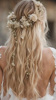 the back of a woman's head with long blonde hair and flowers in her hair