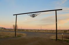 an eye shaped sculpture on the side of a road