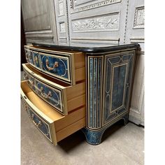 an ornate blue and gold dresser with drawers