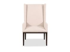 an upholstered beige chair with studding on the arm and backrests