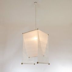 a light fixture hanging from the ceiling in a room with white walls and flooring