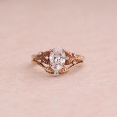 a close up of a diamond ring on a pink surface with white and brown diamonds