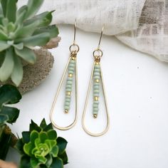 Add a touch of fun and femininity with our Harley gold teardrop earrings, adorned with delicate mint green seed beads. Perfect for any occasion (and any outfit), these long earrings will complete your look and add a hint of whimsy to your style. A must-have for any accessory lover! Approximately 2.25” long Made with 14k Gold Filled Light Mint Green Seed Beads Polished to a high shine Handmade in Montana Sent in a ribboned gift box with polishing cloth Gold Bohemian Teardrop Earrings For Summer, Green Teardrop Jewelry For Summer, Summer Bohemian Gold Teardrop Earrings, Beaded Teardrop Earrings For Summer, Green Teardrop Earrings With Tiny Beads, Gold Teardrop Earrings For Summer, Summer Beaded Teardrop Earrings, Elegant Green Beaded Teardrop Earrings, Green Teardrop Beaded Earrings With Tiny Beads