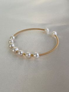 Genuine fresh water bangle with gold faceted beads gold color. Elegant Gold Bead Bangle, Elegant Gold Bangle With Round Beads, Elegant Gold Beaded Bangle, Gold Beaded Bangle Pearl Bracelet, Gold Beaded Pearl Bangle Bracelet, Gold Pearl Bangle Bracelet, Adjustable Gold Pearl Bangle Bracelet, Gold Bangle With Gold Beads, Gold Pearl Bangle Cuff Bracelet