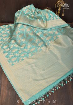 Look your best with this luxurious Pure Katan Silk Banarasi Saree. It is woven in the traditional Katan Jaal style, featuring a fine net-like pattern and an elegant floral jaal design in gold brocade zari. This timeless garment is highly durable and perfect for special occasions, ideal for a sophisticated look that exudes elegance and grace. SILK MARK CERTIFIED This saree is ready to wear with fall and pico done. Handmade silk tassels adorn the pallu and add more grace to it. An unstitched blous Luxury Katan Silk Unstitched Saree Suit, Luxury Katan Silk Blouse With Zari Weaving, Luxury Katan Silk Unstitched Blouse, Luxury Unstitched Katan Silk Blouse, Luxury Katan Silk Handloom Pre-draped Saree, Luxury Katan Silk Salwar Kameez With Zari Weaving, Luxury Unstitched Silk Mark Certified Saree, Luxury Katan Silk Saree With Cutdana Detailing, Glowing Aura