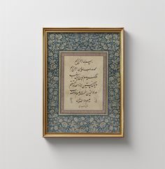 an old arabic calligraphy is framed in gold and blue with ornate writing on it