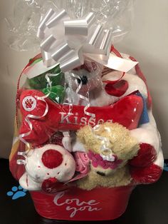 a red basket filled with lots of stuffed animals and gifts for someone's special occasion