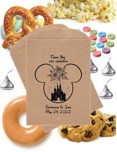 an envelope with a mickey mouse design and some cookies, pretzels, and candy