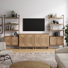 a living room with furniture and a flat screen tv mounted on the wall above it