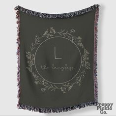 an embroidered wall hanging with the word love in a circle surrounded by flowers and leaves