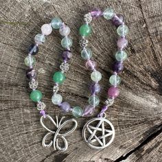 "Visions of butterflies fluttering and lilacs blooming inspired the creation of this beautiful, OOAK set of prayer beads. Made to carry with you or adorn your altar, these unique prayer beads feature the following: 8mm polished, round fluorite beads 8mm polished, round green aventurine beads 6mm silver tone flower spacer beads Each bead is individually hand-knotted on durable, lilac colored nylon thread with a silver tone pentacle on one end and a silver tone metal alloy butterfly on the other end. Total length is approximately 15 1/8 inches. 💜 Fluorite is a protective stone that is used to ground and harmonize spiritual energy. Believed to increase intuitive abilities and foster a connection to Spirit.  💚 Green Aventurine grounds and stabilizes the energetic field. Known as the \"stone Bohemian Purple Polished Beads, Spiritual Purple Beaded Necklaces With Colorful Beads, Spiritual Purple Beaded Necklace With Colorful Beads, Hand-strung Purple Bohemian Beads, Purple Hand-strung Bohemian Beads, Purple Bohemian Hand-strung Beads, Bohemian Hand-strung Purple Beads, Purple Spiritual Beaded Bracelets For Festivals, Spiritual Purple Beaded Bracelets For Festivals