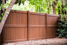 a wooden fence in front of some trees