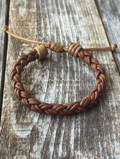 a close up of a bracelet on a wooden surface with a string attached to it