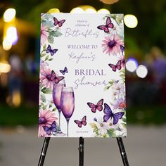 a welcome sign for a bride and groom with butterflies on the back is shown in front of an outdoor setting