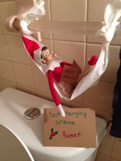 an elf is hanging on the toilet paper