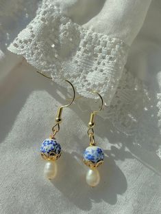 Dainty, trendy, hypoallergenic gold drop earrings with porcelain blue and white beads, gold finishes, and imperfect pearls. Beaded Cloud Earrings, Porcelain Beads Jewelry, Dainty Beaded Earrings, Blue Drop Pearl Earrings With Pearl Charm, Blue Pearl Charm Earrings As Gift, Handmade Blue Pearl Earrings, Blue And White Earrings, Bijoux Fil Aluminium, Porcelain Beads