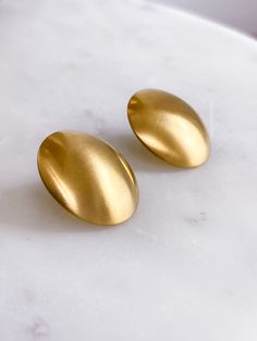 Stainless steel. Everyday Metal Earrings With Polished Finish, Matte Gold Round Tarnish Resistant Earrings, Polished Metal Clip-on Earrings As Gift, Polished Metal Clip-on Earrings For Gift, Metal Clip-on Earrings With Polished Finish For Gift, Minimalist Metal Earrings With Shiny Finish, Matte Gold Round Earrings, Modern Oval Clip-on Earrings For Gift, Modern Matte Gold Earrings